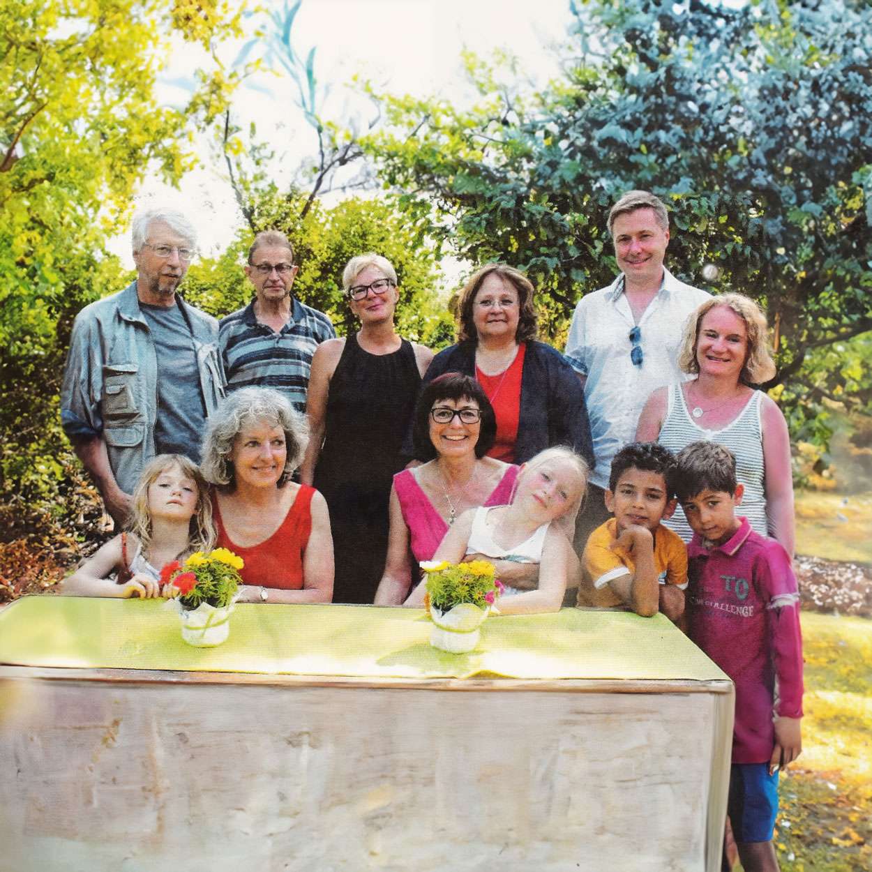 Familienfoto im Garten mit drei Generationen.