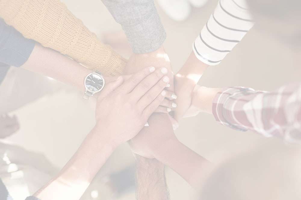 Team stapelt Hände für Zusammenarbeit und Einheit.