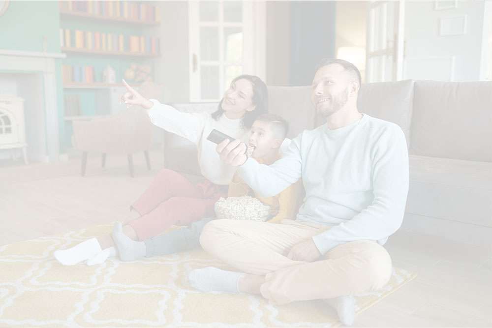 Familie beim gemeinsamen Fernsehen im Wohnzimmer.